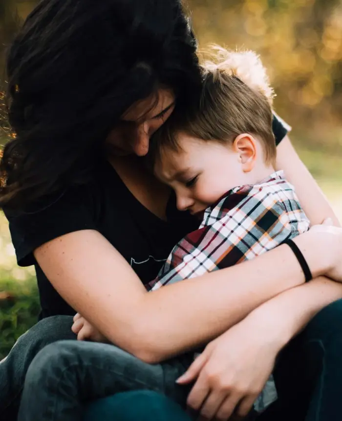 Una madre abrazando a su hijo pequeño en su regazo