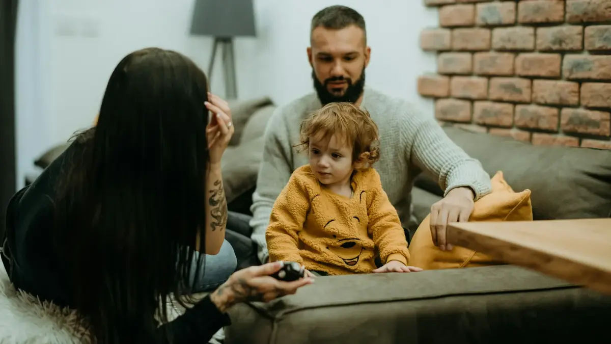 Un padre hablando con calma a la altura de un niño en un momento difícil